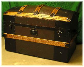 dome top with embossed pebble pattern tin, before and after pictures,  new 2 color  paint on embossed tin, refinished slats, new  leather, &  newspaper pattern lining.

This beautiful dome top trunk along with  a flat top ( not pictured) is on display in San Diego, California  as part of a  City History exhibit.